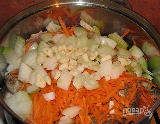 Очистим лук, чеснок и морковь. Лук нарежем четверть-кольцами, а морковь натираем на терке. Чеснок мелко нарезаем. Овощи можно обжарить, а затем добавить к ножкам, а можно добавить сырыми.