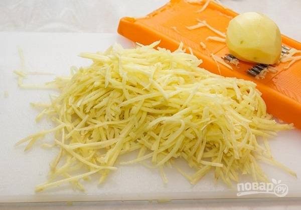 1. Начать процесс следует с очистки картофеля. Нарежьте его очень тонкими брусочками или натрите на терке для корейской моркови. 
