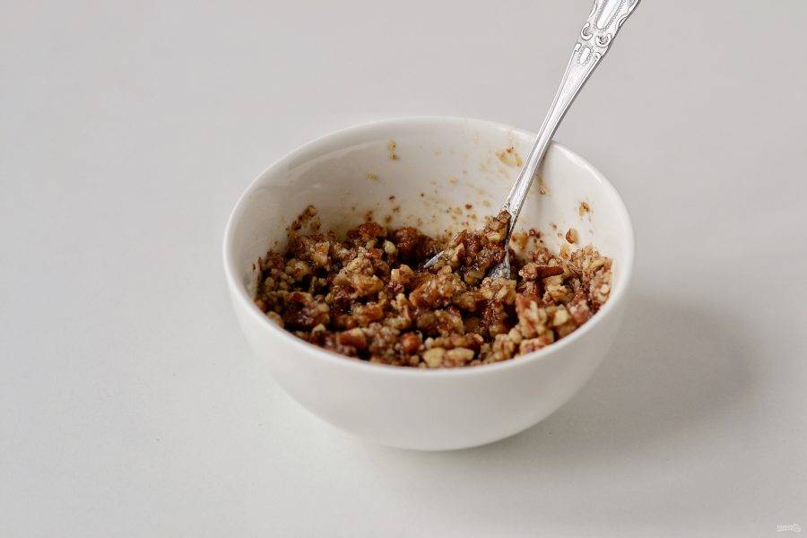Для начинки измельчите орехи в крупную крошку, добавьте кленовый сироп и перемешайте. Пару орехов оставьте для украшения слоек. 