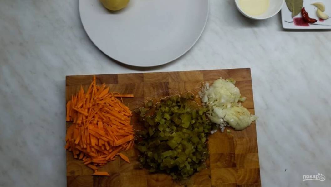 1. Для начала отварите перловую крупу. Нарежьте все овощи: морковь — тонкой соломкой, лук — мелкими кубиками, огурец — мелкими кубиками, картофель — кубиками. 