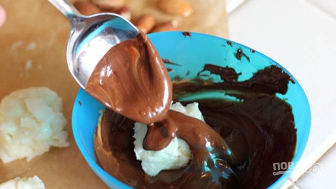 Влажными руками из кокосовой смеси скатайте шарик, обваляйте их в растопленном шоколаде и придайте форму конфеток.