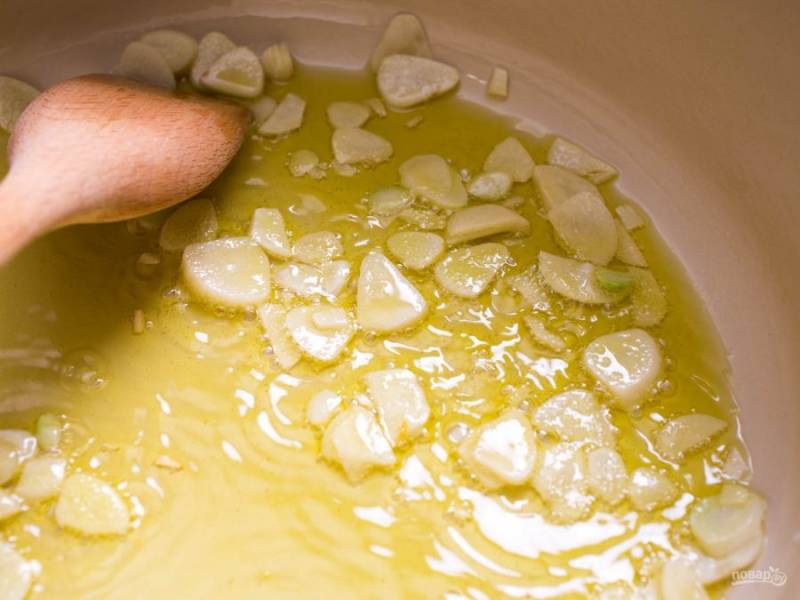 3.	В кастрюле или в казанке разогрейте 0,5 стакана оливкового масла, выложите чеснок, готовьте 3-4 минуты.