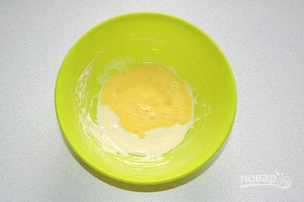 Влейте яйца в тесто. Тщательно перемешайте до однородности. Параллельно растопите на сковороде сливочное масло.