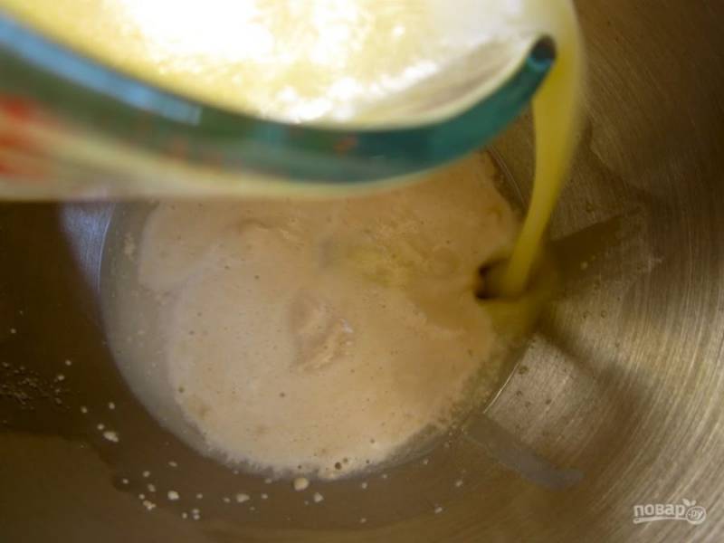 2.	В отдельной миске смешайте теплое молоко, растопленное сливочное масло и яйца. Как заметили, что начали появляться пузырьки, влейте приготовленную жидкость.