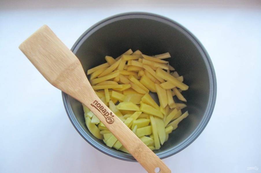 В чашу мультиварки налейте подсолнечное масло и хорошо нагрейте его в режиме "Жарка". Выложите картошку.