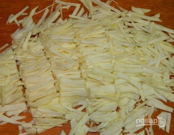1. Первым делом поставьте вариться яйца и замаринуйте лук. В небольшой мисочке соедините воду, уксус, сахар и соль. Добавьте нарезанный тонко лук, оставьте на время. Капусту нашинкуйте и выложите в глубокий салатник.