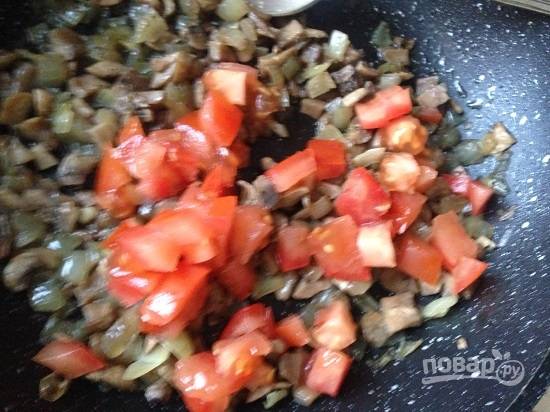 И затем к обжаренным грибам добавим мелко нарезанный помидор. Солим по вкусу, обжариваем еще минуты 3.