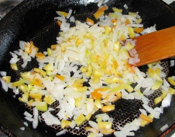 3. Обжарить на среднем огне немного овощи, а тем временем нарезать небольшими кусочками колбасу. Использовать можно как копченую, так и вареную колбаску. 