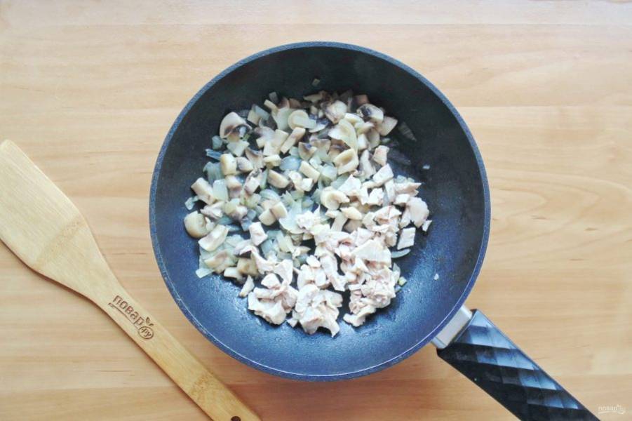 Налейте растительное масло и поджарьте лук с грибами до прозрачности лука. Затем добавьте нарезанную отварную курицу.