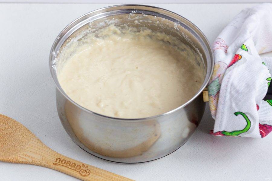 Затем постепенно введите смесь муки и дрожжей. Накройте крышкой или полотенцем и поставьте в теплое место на 30-40 минут, чтобы тесто поднялось.