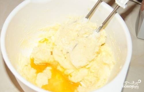 Яйца разделите на белки и желтки. Белки отложите на крем, а желтки добавьте в масляную смесь.