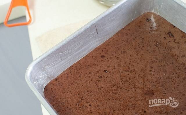10. Добавьте масло с какао в тесто, перемешайте лопаткой. Форму для выпекания смажьте сливочным маслом и вылейте в нее тесто.