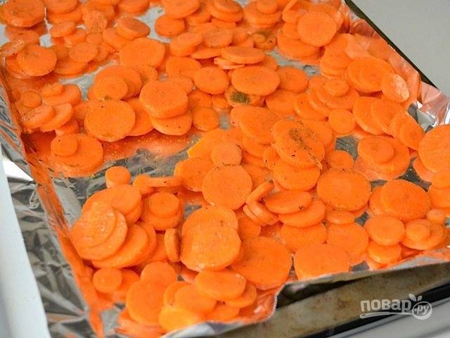 3.	Перемешайте морковь. Застелите противень фольгой и выложите на него морковь, разровняйте ее в один слой.