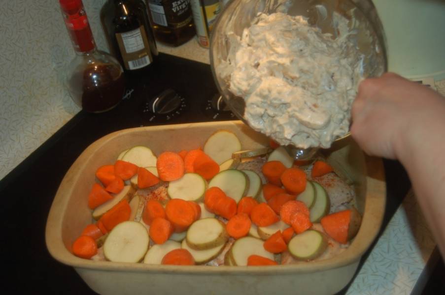 3. От картошки отделим треть, остальное с морковкой выкладываем слоями в форму для запекания, смазанную маслом. Поливаем сметанно-грибным соусом, затем — оставшиеся кружки картошки. Сверху выкладываем небольшие кусочки сливочного масла. 