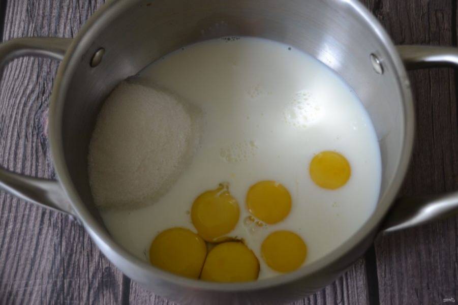 Смешайте яичные желтки, 1.5 стакана молока и сахар.