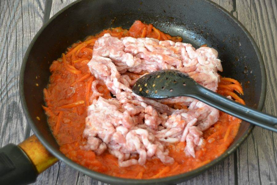 Когда томаты обжарятся, добавьте мясной фарш, разровняйте его ложкой, накройте крышкой и продолжайте обжаривание до готовности под крышкой. В это время поставьте воду для отваривания риса. 