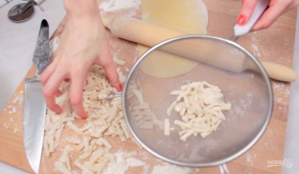 3.  Далее раскатайте тесто толщиной примерно 3-5 мм и разрежьте его на полоски (можете воспользоваться ножом). Выложите нарезанные полоски в сито и встряхните, чтобы убрать излишки муки. 