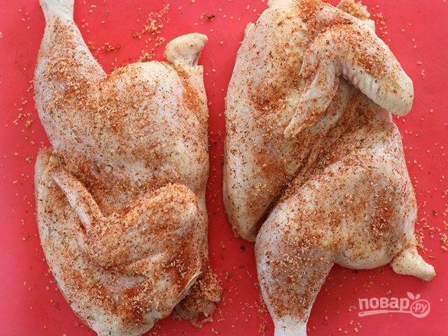 1.	Вымойте курицу, разрежьте ее пополам или на несколько кусочков. Натрите каждую половинку смесью специй и солью.