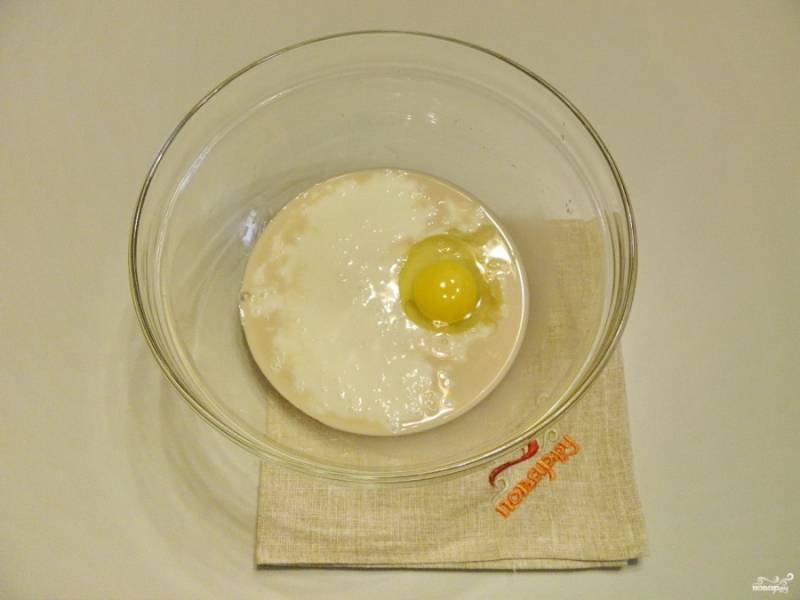 Добавьте сырое яйцо и кефир комнатной температуры. Перемешайте.
