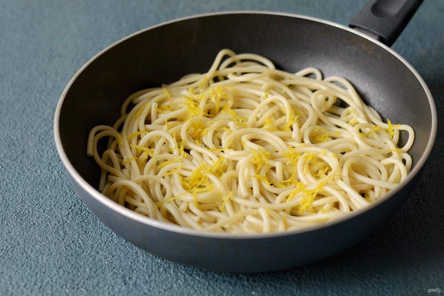 Спагетти отварите в кипящей подсоленной воде до готовности. Затем выложите их в сковороду с чесноком. Добавьте цедру и немного воды, в которой варились спагетти. Погрейте, чтобы все вкусы перемешались. 