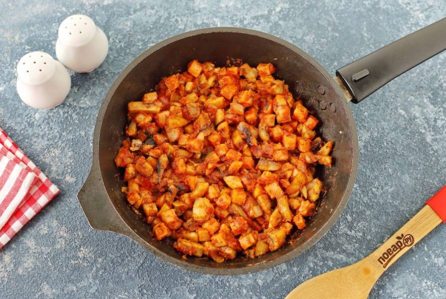 Добавьте муку, специи, перемешайте, добавьте томатную пасту и продолжая помешивать готовьте еще 1-2 минуты.