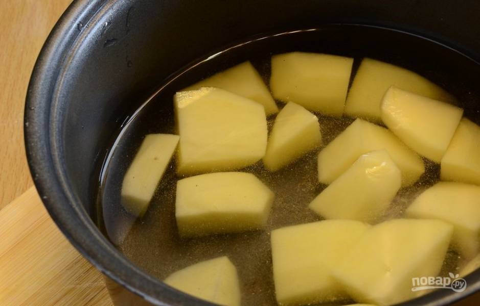 Картофель почистите, промойте и нарежьте средними кусочками. Чтобы получилась хрустящая корочка, должен уйти лишний крахмал. Поэтому отварите картофель в воде в течение 7-10 минут.