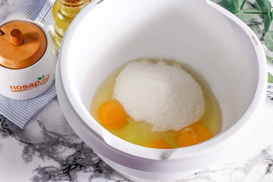 Взбейте в чаше миксера или кухонного комбайна куриные яйца с сахаром и солью в пышную пену примерно 3-5 минут.