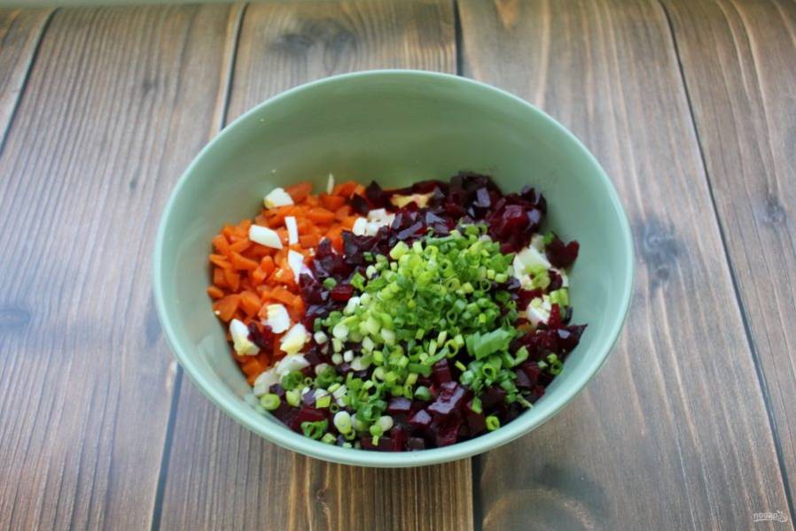 Зеленый лук мелко нарежьте и выложите в салат. Свеклу сварите, охладите, очистите и нарежьте, как морковь и картофель.