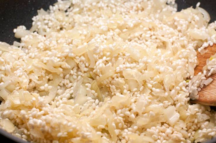 Засыпьте рис, перемешайте содержимое. Готовьте несколько минут, пока рис не пропитается маслом.