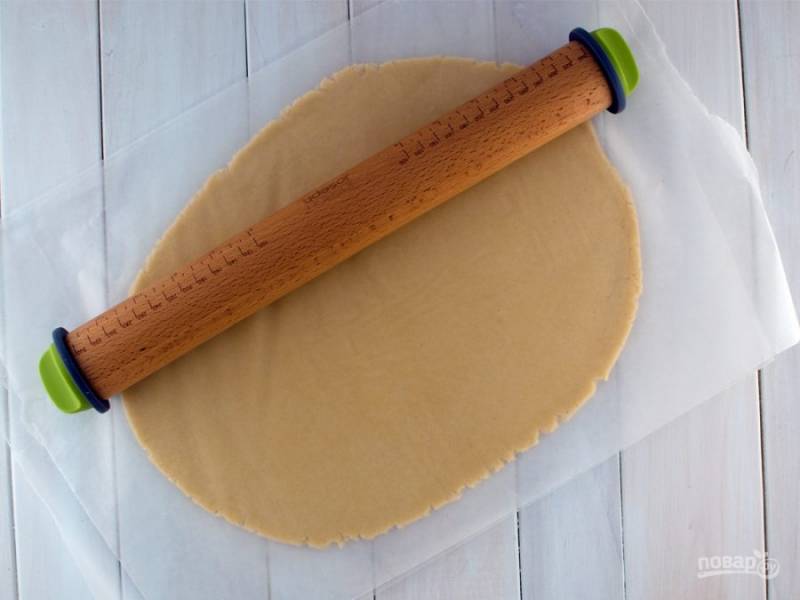 Когда тесто станет пластичным, раскатайте его между кусков пергамента в слой 3-4 мм, а затем охладите минимум 30 минут.