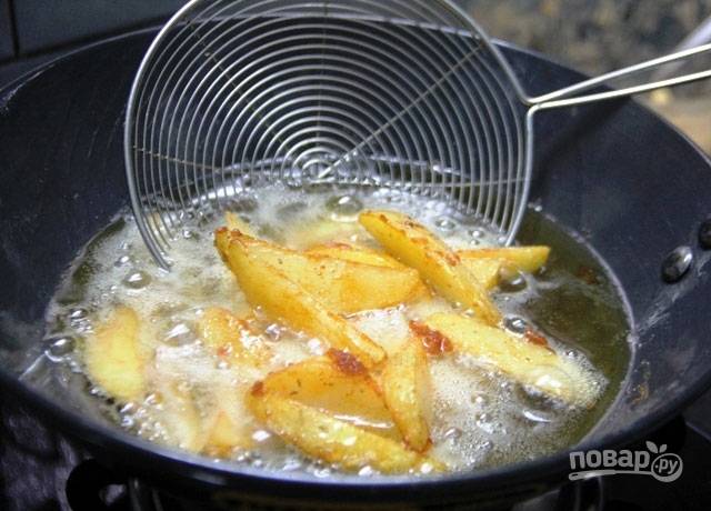 Раскалите масло и отправьте картофель жариться во фритюре до золотистой корочки.