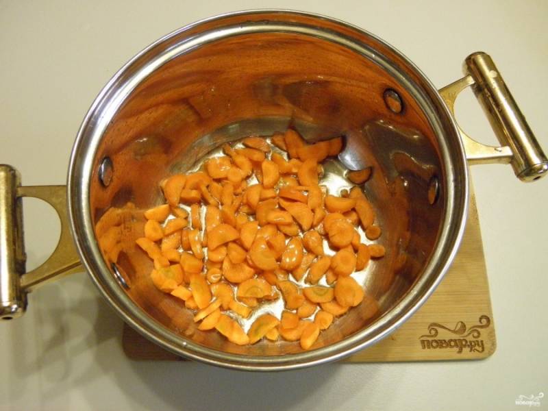 Очистите и порежьте небольшими кусочками морковь. Обжарьте ее в кастрюле с толстым дном на растительном масле под крышкой (минут 5-6).