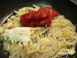 Добавляем муку и томатную пасту, размешиваем и жарим 2-3 минуты.