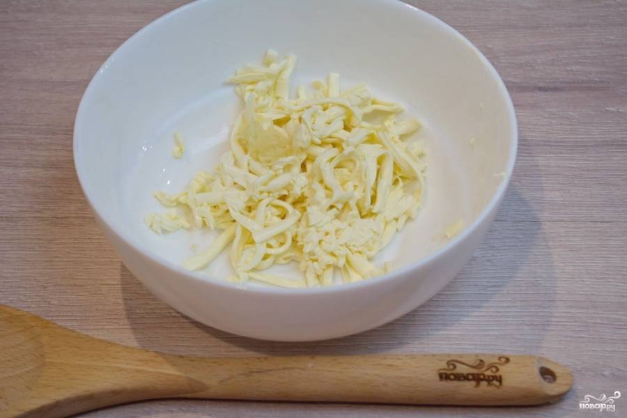 Для приготовления блюда плавленый сыр немного подержите в морозилке. Он будет плотнее. Легче будет натирать его на терке. Натрите сыр на крупной терке.