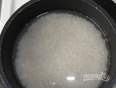 Выкладываем промытый рис в толстостенную кастрюлю, заливаем его водой. Ставим на большой огонь.