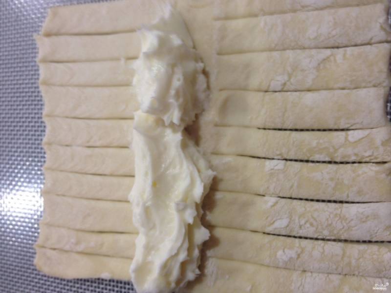 Шаг 3. Распределите сливочный сыр по центру теста, между разрезами.