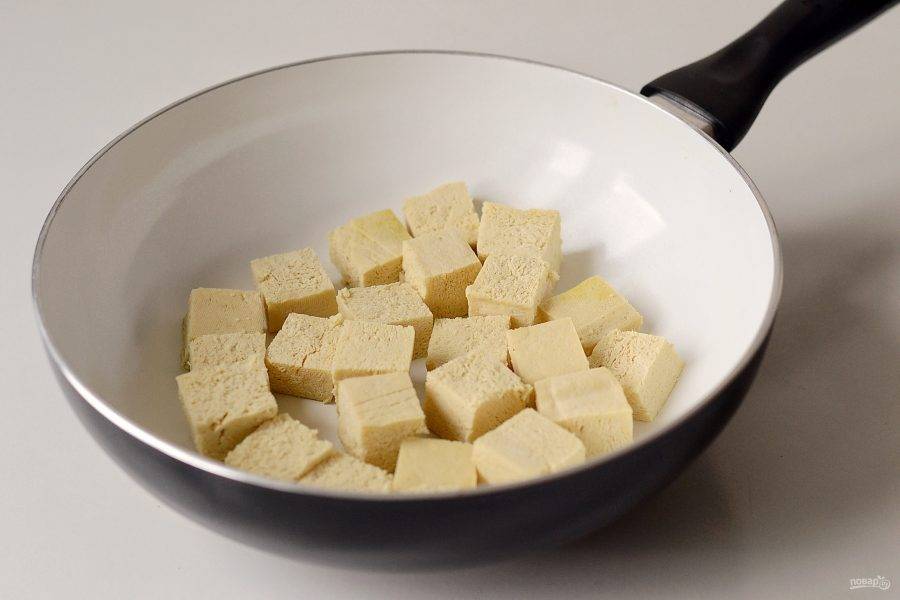 Разогрейте сковороду на среднем огне. Обжарьте тофу нарезанный кубиками до золотистой корочки. Затем переложите в миску.