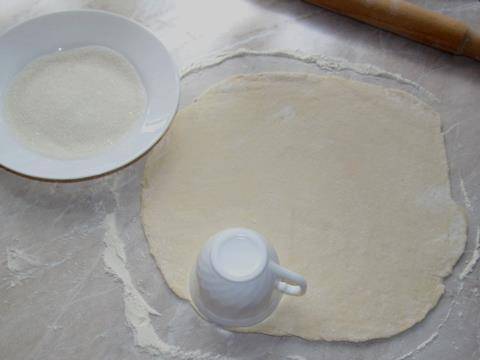 Раскатываем тесто в тонкий пласт, толщиной 0,3-0,5 см. Затем стаканом или кружкой выдавливаем  из теста кружочки.