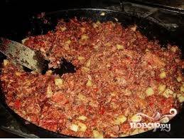 6.	Затем добавляем к мясу разведенную томатную пасту, соль и специи, перемешиваем. Накрываем сковороду крышкой, уменьшаем огонь. Тушим 7 минут.