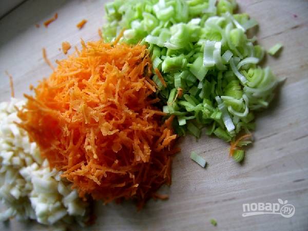 2. Капусту откиньте на дуршлаг, затем выложите в большую миску. Яблоко и луковицу почистите и мелко нарежьте, лук-порей нарубите, очищенную морковь натрите на мелкой терке.
