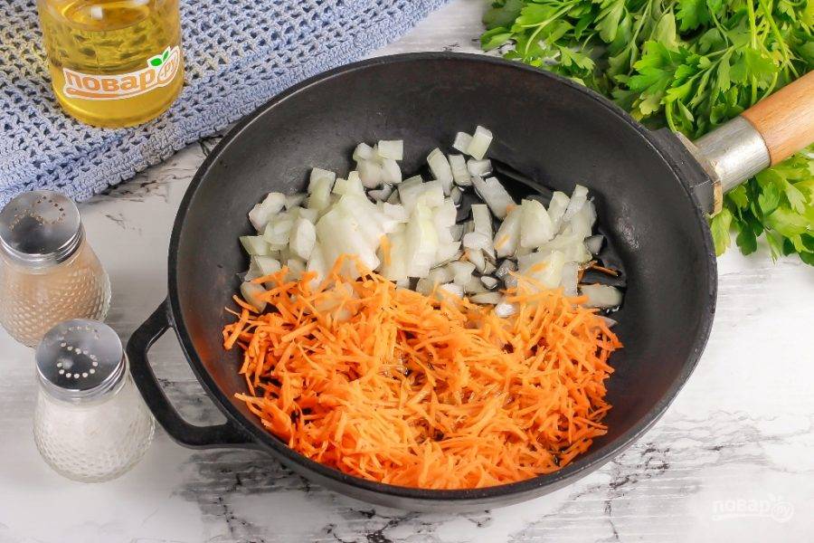 Нарежьте лук мелкими кубиками, а морковь натрите на терке с мелкими ячейками. Прогрейте на сковороде растительное масло и отпассеруйте в нем овощные нарезки примерно 3-5 минут до румяности.