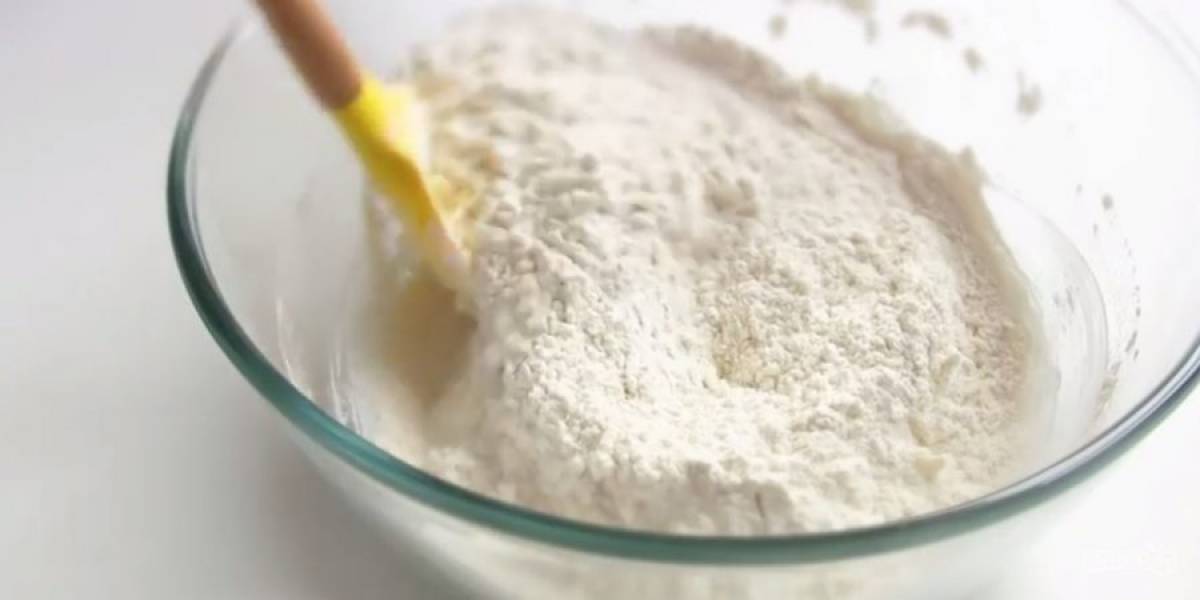 1. Приготовьте тесто: сметану 20% жирности перемешайте с сахаром. В отдельной миске смешайте просеянную муку с разрыхлителем. Добавьте сухие ингредиенты к сметане и перемешайте. 