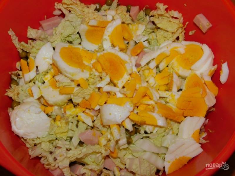 Добавьте нарезанные яйца. Заправьте салат майонезом и перемешайте.