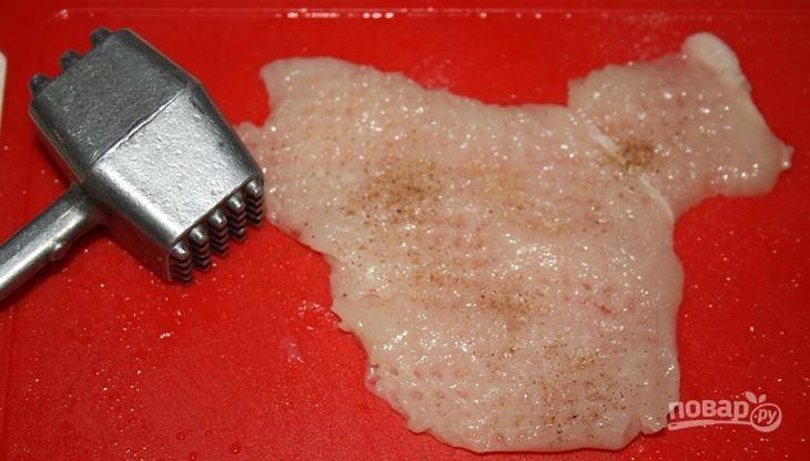 Куриное филе вымойте, обсушите и зачистите от пленок. Затем нарежьте его на пласты, отбейте кусочки, натрите солью и перцем. 