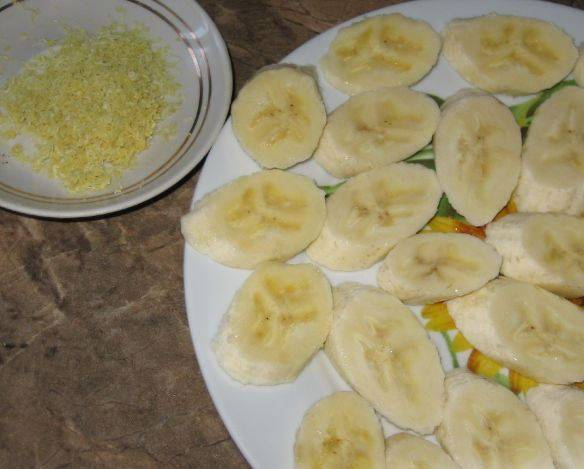 Цедру лимона натрите на терке, отдельно выжимаем лимонный сок. Два банана порежьте ломтиками и сбрызнете лимонным соком, чтоб не темнели. Остальные бананы мелко порежьте и разомните вилкой в кашицу. Яичные желтки смешайте со 100 грамм сахара, затем взбейте миксером с мятыми бананами, лимонным соком, цедрой и сметаной. Получится жидкий крем.