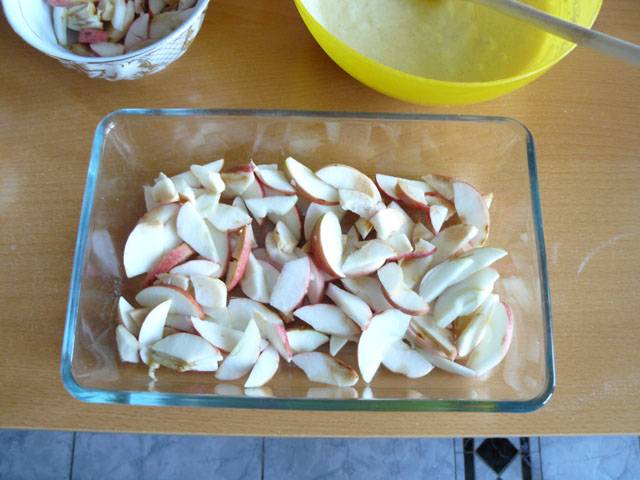 3. Нарежьте яблоки. Я брала для шарлотки кисло-сладкие яблоки и не снимала с них кожуру. Выложите их на дно формы для выпекания.
