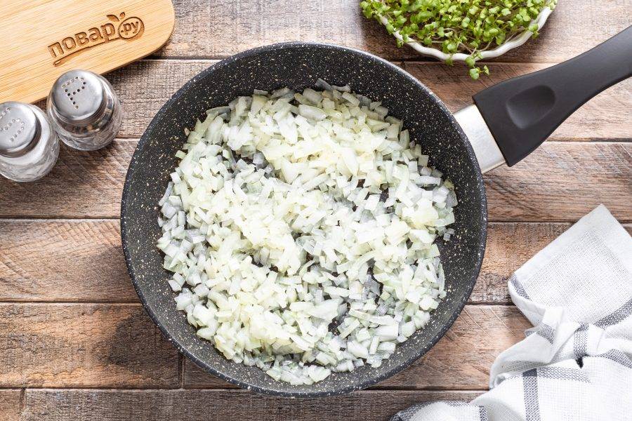 Разогрейте сковороду с растительным масло на среднем огне. Выложите репчатый лук. Жарьте до прозрачности и легкой золотистости около 4-5 минут.