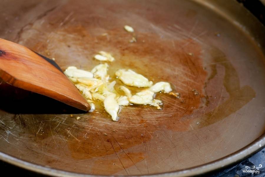 Поставьте макароны вариться. Тем временем нарежьте чеснок тонкими пластинами и обжарьте на сковороде.