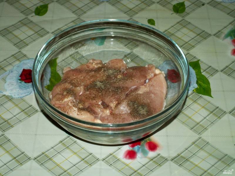 3. Положите подготовленные грудки в удобную посуду. Затем посолите и добавьте по вкусу молотый перец.