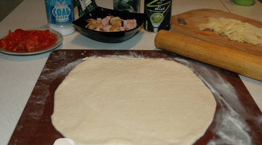2. Раскатываем тесто в тонкую лепешку, чуть-чуть солим и перчим. 